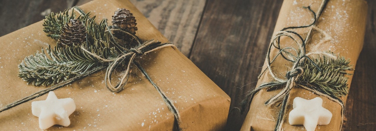 pile of presents wrapped in brown paper with fir clippings