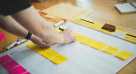 Person arranging post it notes on a flip chart