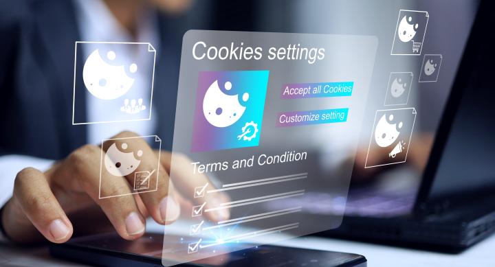 user touching cell phone that is laid flat on a table. A projection of their screen is visible in the air showing a cookies setting window with options to opt out or accept.