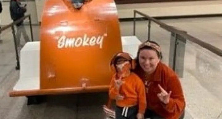 woman and child near orange cannon that says Smokey