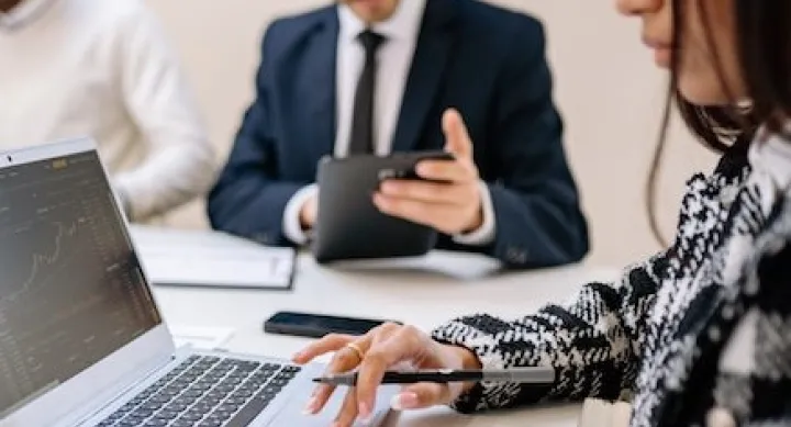 woman working at computer with others inbackground