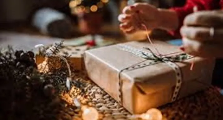 hands wrapping brown paper on present